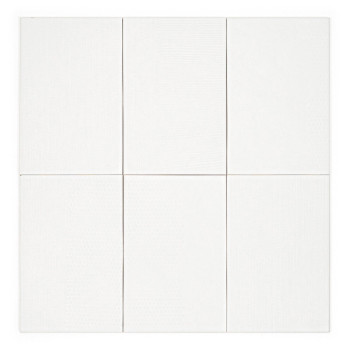 Le carreau blanc est aligné verticalement, mettant en valeur une subtile texture en nid d’abeille, sur un fond uni et indistinct