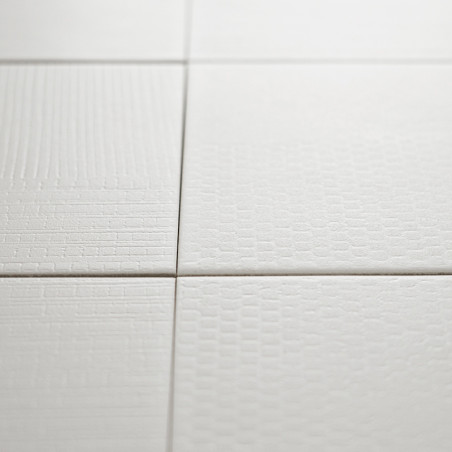 Ladrilhos texturizados brancos exibem padrões sutis e variados em uma formação de grade, criando um design de superfície minimal