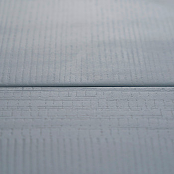 Eine glatte, hellblaue Fliese mit subtilen, linearen Texturen liegt flach und sorgt für ein modernes, minimalistisches Erscheinu