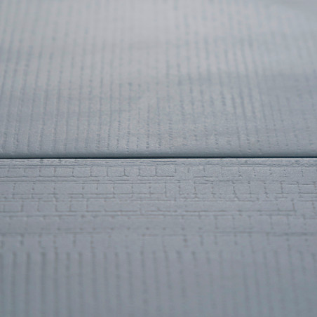 Eine glatte, hellblaue Fliese mit subtilen, linearen Texturen liegt flach und sorgt für ein modernes, minimalistisches Erscheinu