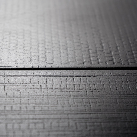 Le carreau présente une surface texturée avec un subtil motif de grille, posé à plat dans un décor neutre et minimaliste. Aucun 