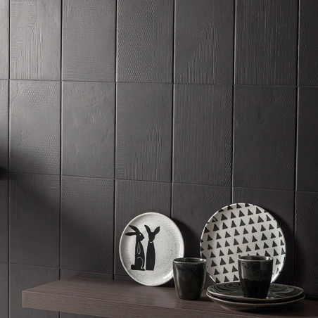 Los azulejos oscuros y texturizados forman una pared moderna. Los platos con diseños minimalistas de conejos y triángulos descan