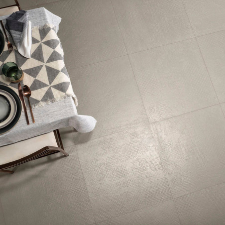 Los azulejos beige forman un suelo liso y sin costuras que refleja la luz. Al lado hay una mesa de comedor con manteles, platos 