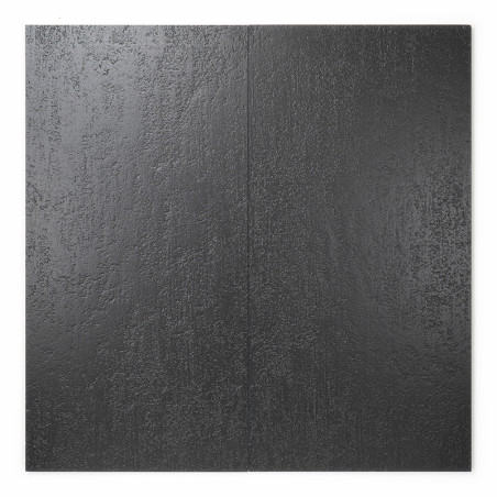 A large, flat, black ceramic tile features a subtle textured surface resembling stone, reflecting light. Its displayed against a