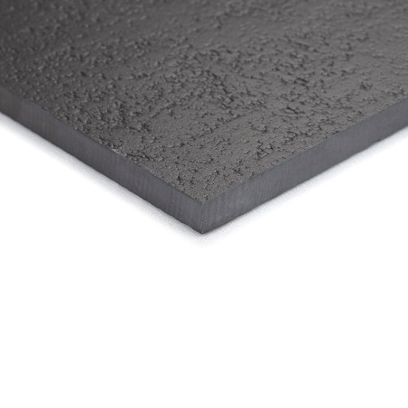 A textured, dark gray tile with a slightly rough surface lies flat on a white background, displaying its thickness and corner de