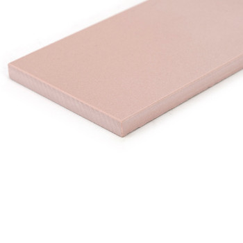 Un carreau de céramique rectangulaire rose repose sur un fond blanc, présentant une surface lisse et des bords légèrement biseau