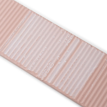 Un azulejo cerámico rectangular de color beige presenta una textura acanalada y un texto sangrado que dice `TILE LINES`, con un 