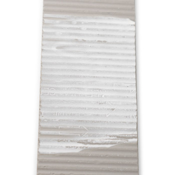 O ladrilho retangular exibe cristas horizontais, com texto parcial escrito "MADE IN" e setas direcionais, colocadas sobre um fun