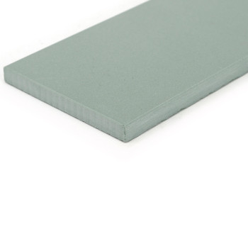 A flat, rectangular, light green tile lies on a white surface, displaying its smooth surface and thin, uniform thickness.