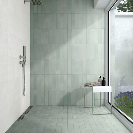 El área de la ducha presenta azulejos verdes verticales en la pared y el piso, bordeados por una gran ventana de vidrio con vist