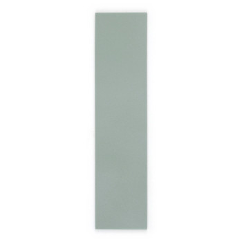 Un long carreau rectangulaire vert clair se dresse sur un fond blanc uni, mettant en valeur sa texture de surface lisse et mate.