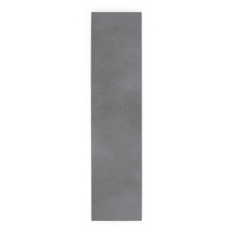 Un long carreau gris rectangulaire repose à plat, affichant une surface lisse et solide sans marques visibles, sur un fond blanc
