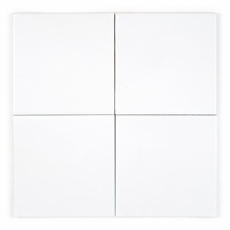 Quatre carreaux carrés blancs sont disposés dans une grille deux par deux avec de fines lignes noires les séparant, soulignant l