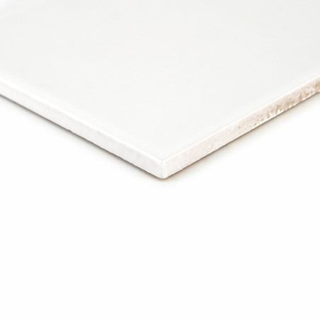 Eine weiße Keramikfliese mit glatten Kanten liegt auf einem schlichten, hellen Hintergrund und betont deren glänzende Oberfläche Eine weiße Keramikfliese mit glatten Kanten liegt auf einem schlichten, hellen Hintergrund und betont deren glänzende Oberfläche