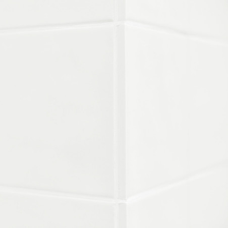 Los azulejos de cerámica blanca forman un rincón limpio y reflejan la luz sutilmente. La superficie lisa sugiere un ambiente de 