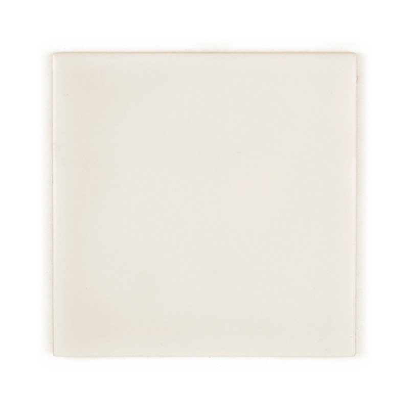 Um ladrilho cerâmico liso e quadrado repousa sobre um fundo branco, exibindo uma superfície branco-creme uniforme com variações 