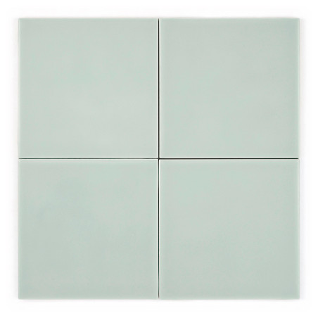 Vier hellgrüne quadratische Fliesen sind in einem 2x2-Raster angeordnet und bilden ein einfaches, symmetrisches Muster auf einem Vier hellgrüne quadratische Fliesen sind in einem 2x2-Raster angeordnet und bilden ein einfaches, symmetrisches Muster auf einem