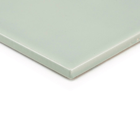 Um ladrilho cerâmico liso, verde e quadrado fica plano sobre um fundo branco, exibindo suas bordas limpas e acabamento brilhante