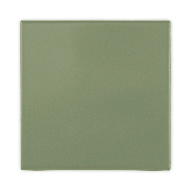 Un carreau de céramique uni, carré, vert sauge, avec une surface lisse. il est isolé sur un fond blanc.