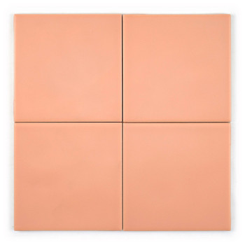 Een gladde, perzikkleurige keramische tegel rust op een effen witte achtergrond. De tegel is vierkant met een glanzende afwerkin