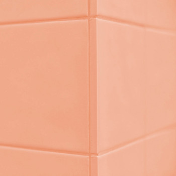 Peach-colored tiles form a corner pattern, intersecting with clean grout lines, creating a smooth, uniform wall surface.