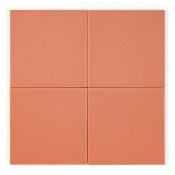 Een gladde, vierkante perzikkleurige keramische tegel, rustend op een vlak, lichtgekleurd oppervlak, met een subtiele matte afwe