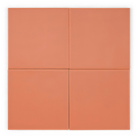Quatre carreaux carrés et lisses de couleur terre cuite sont disposés uniformément dans une grille 2x2 sur un fond blanc uni.