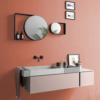 Een moderne badkamer is voorzien van een zwevende wastafel met een rechthoekige wastafel, ronde spiegels die het groen reflecter