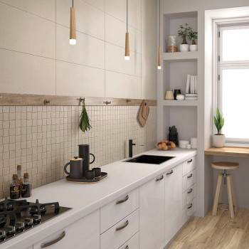 Modern kitchen features sleek white cabinets along a wooden floor, with a tan tiled backsplash. Hanging lights illuminate the co