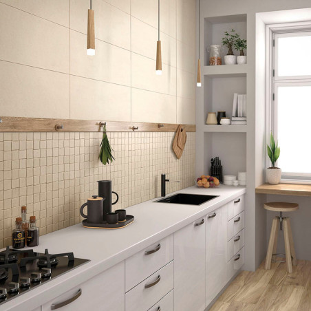 Cuisine avec armoires blanches et comptoirs en bois, dotée d'une cuisinière et d'un évier noirs. Des lampes suspendues illuminen