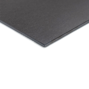 Una losa rectangular, lisa y oscura, descansa plana sobre una superficie blanca, enfatizando sus bordes elegantes y su grosor un