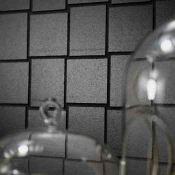 Los azulejos cuadrados grises forman un patrón de cuadrícula en una pared, con reflejos de cúpulas de vidrio en primer plano, cr