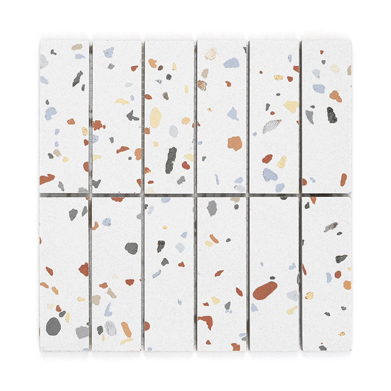 Les carreaux de céramique présentent des motifs de terrazzo multicolores dispersés sur un fond blanc, disposés en rangées vertic