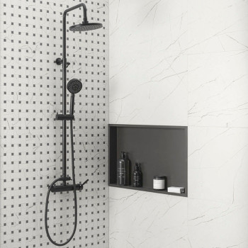 A black shower fixture stands against a white tiled wall with a square pattern, adjacent to a built-in shelf holding toiletries.