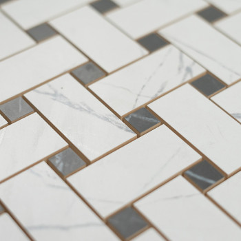 Los azulejos blancos rectangulares con sutiles vetas grises están dispuestos en un patrón de ladrillo escalonado, intercalados c