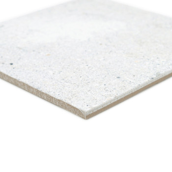 Um ladrilho cerâmico liso e quadrado repousa sobre um fundo branco, mostrando uma superfície manchada de cinza claro e bege.