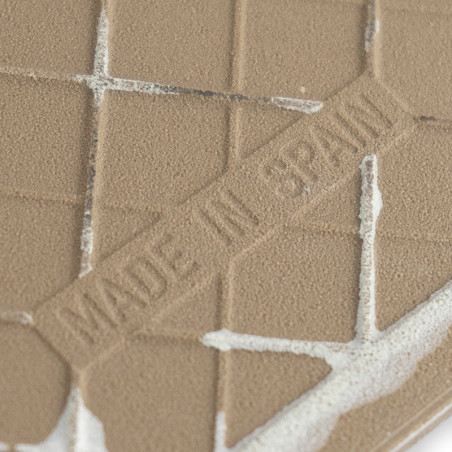 Um azulejo cerâmico marrom texturizado apresenta linhas de grade em relevo e o texto "MADE IN SPAIN", colocado sobre um fundo li Um azulejo cerâmico marrom texturizado apresenta linhas de grade em relevo e o texto "MADE IN SPAIN", colocado sobre um fundo li