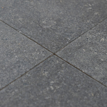 Quatre carreaux de pierre grise se rejoignent en un point central, formant un motif croisé, avec des taches subtiles et une surf