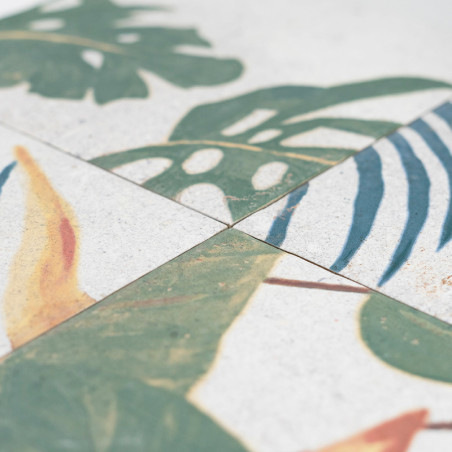 Los azulejos cerámicos presentan diseños de hojas tropicales, principalmente verdes con toques de amarillo y azul. Los mosaicos 