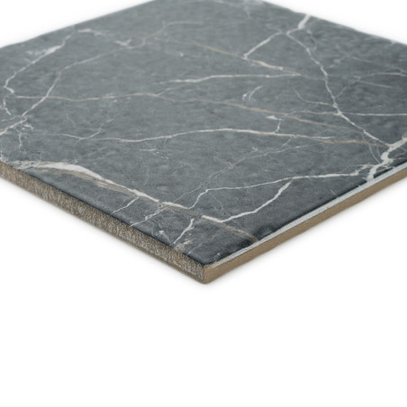 Een vierkante tegel heeft een grijs gemarmerd oppervlak met witte aderpatronen, afgezet tegen een effen witte achtergrond.