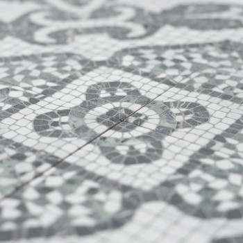 Graue und weiße Mosaikfliesen bilden komplizierte geometrische Muster und betonen Kreis- und Rautenformen. Die Fliesen liegen en