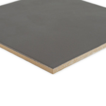Un azulejo cerámico cuadrada de color gris con una superficie lisa y bordes ligeramente rugosos se asienta sobre un fondo blanco