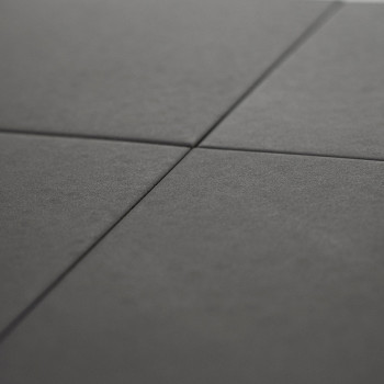 Quatre carreaux carrés gris foncé, disposés selon un motif en grille, se rejoignent en un point central, créant une subtile form