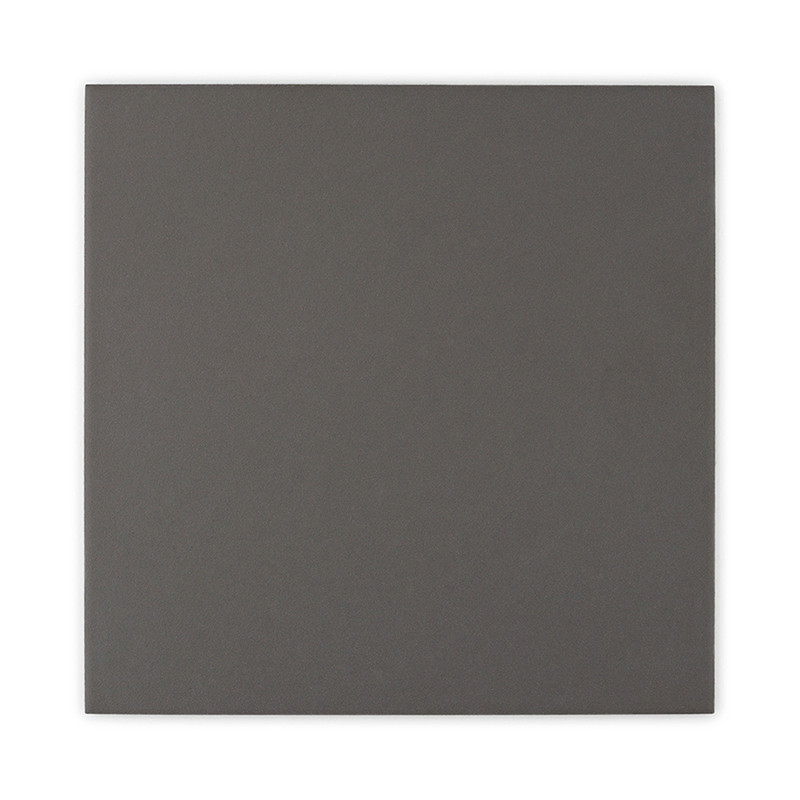 Un mosaico cuadrado oscuro de color sólido que descansa sobre un fondo blanco liso.