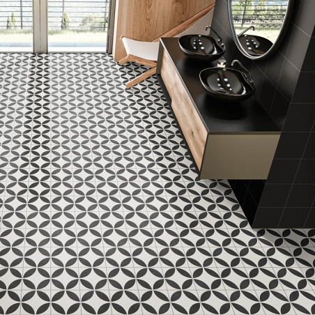 Ladrilhos geométricos pretos e brancos cobrem o piso do banheiro com um padrão circular. pias pretas e espelhos ficam em uma pen