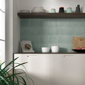 Uma bancada de cozinha exibe tigelas brancas e um livro de receitas intitulado “Mente Saudável” contra um fundo de azulejos verd