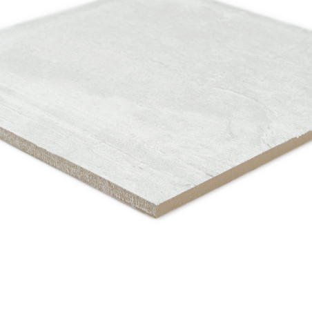 Un carreau rectangulaire gris clair repose sur un fond blanc. La surface des carreaux semble lisse avec une texture subtile et s