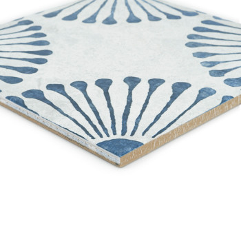Een keramische tegel met een blauw radiaal waaierpatroon op een witte achtergrond. Diagonaal geplaatst, onthult de rand zijn dik