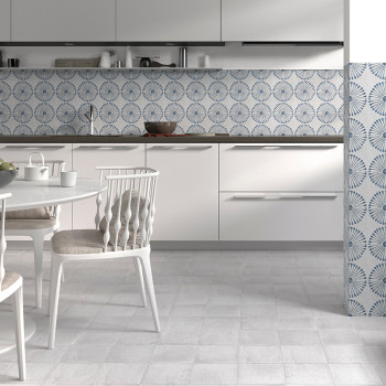Die weiße Küche verfügt über kreisförmig gemusterte blaue Fliesen als Rückwand und minimalistische Schränke und Stühle, die eine