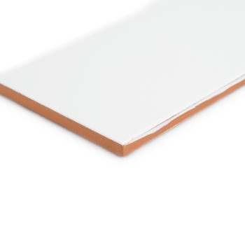 Un carreau rectangulaire avec une surface blanche brillante se trouve sur un fond blanc, révélant un bord marron exposé au coin.